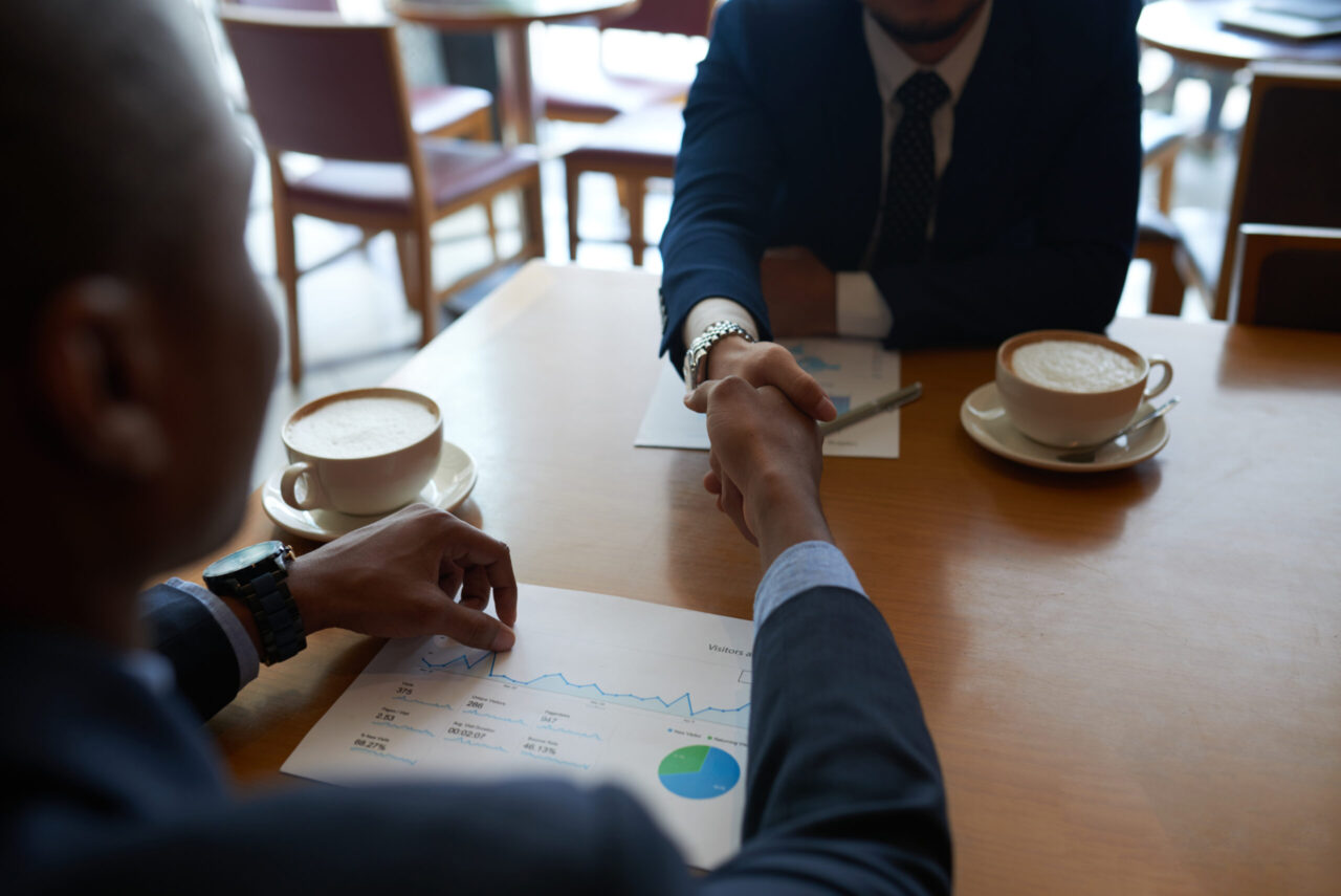 Business partners shaking hands before discussing project